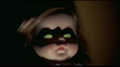 The lighting here makes the scary doll look like Batgirl. They should have just had an unnamed Batman in this movie since they were ripping off wholesale anyway.